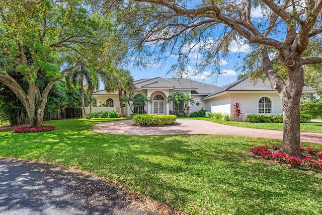 view of front of home with a front lawn, decorative driveway, and stucco siding