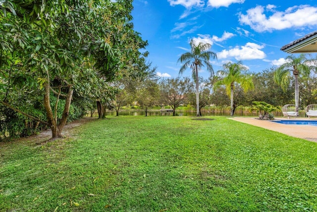 view of yard featuring a water view and a fenced in pool