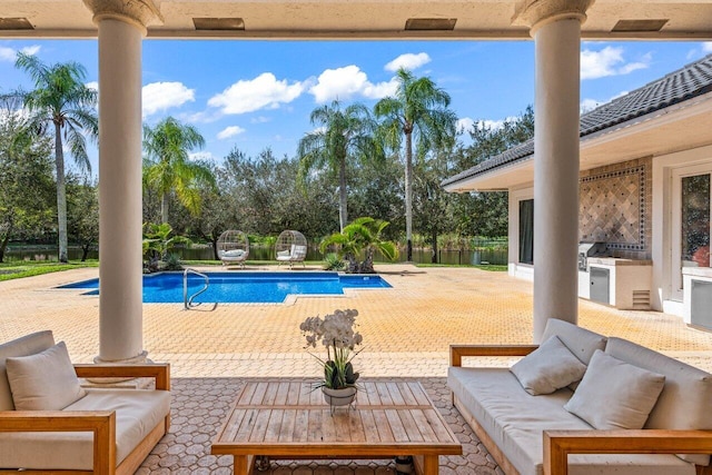 view of pool featuring an outdoor living space, an outdoor kitchen, a fenced in pool, and a patio