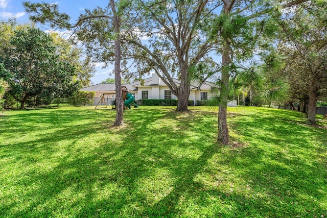 view of yard featuring a playground and fence