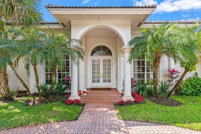 property entrance featuring stucco siding and french doors