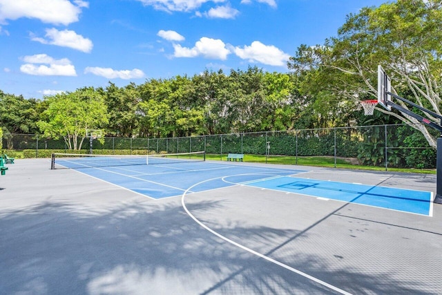 view of basketball court featuring a tennis court, community basketball court, and fence