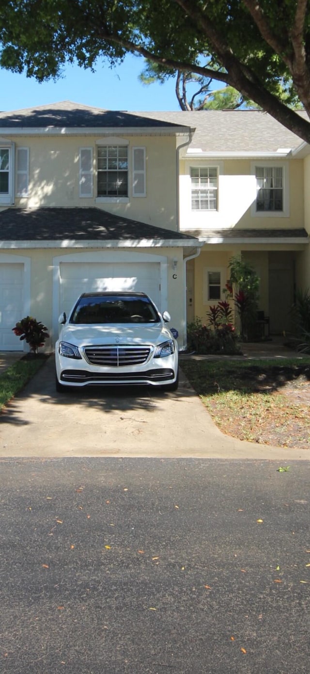 view of front of house featuring driveway, an attached garage, and stucco siding