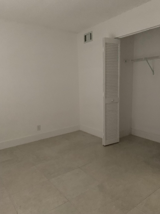 unfurnished bedroom with a closet, visible vents, and baseboards