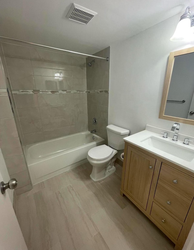 full bathroom featuring toilet, shower / bath combination, vanity, and visible vents