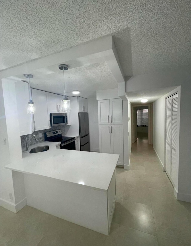 kitchen with refrigerator, pendant lighting, stainless steel microwave, electric range, and white cabinetry