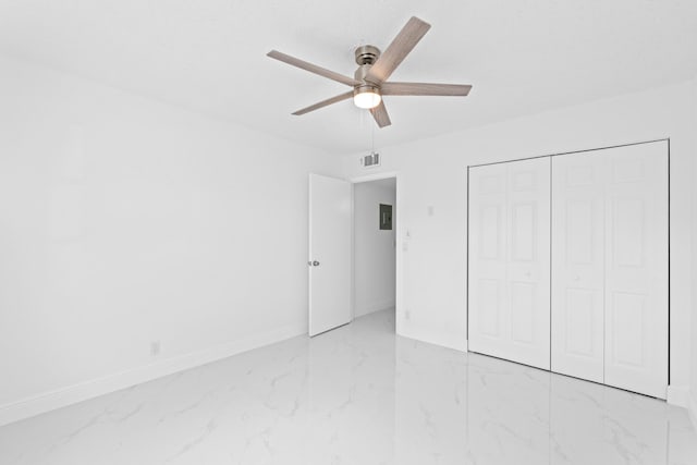 unfurnished bedroom featuring marble finish floor, ceiling fan, baseboards, and a closet