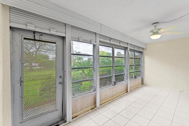 unfurnished sunroom featuring a wealth of natural light and a ceiling fan