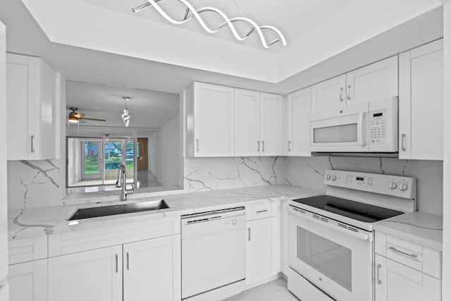 kitchen featuring marble finish floor, decorative backsplash, white cabinets, a sink, and white appliances