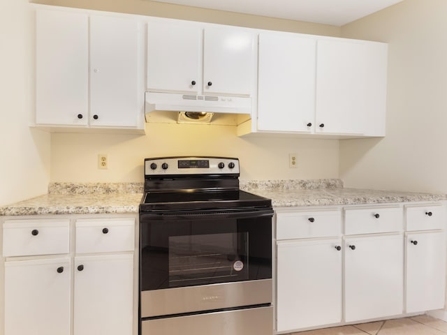 kitchen featuring under cabinet range hood, stainless steel electric stove, light tile patterned floors, and white cabinetry