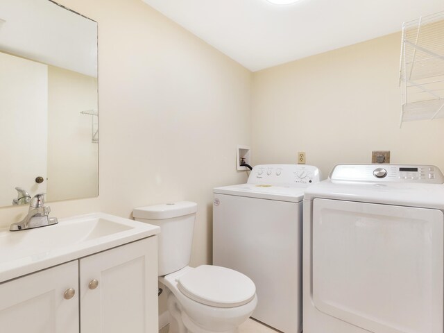 bathroom featuring vanity, toilet, and separate washer and dryer