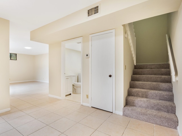 staircase featuring tile patterned flooring, visible vents, and baseboards