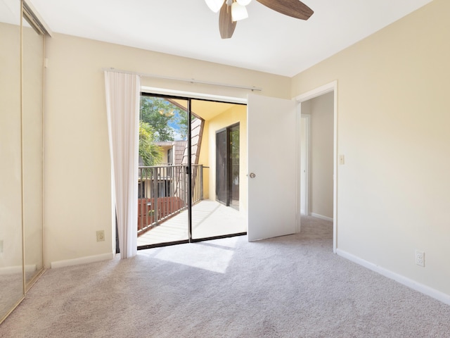 carpeted spare room featuring baseboards and ceiling fan