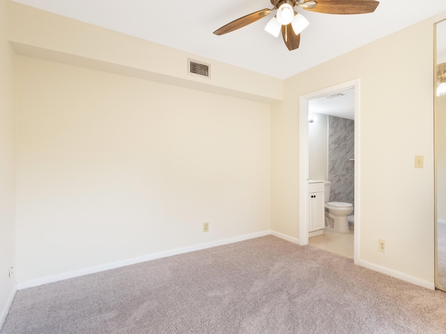 empty room featuring visible vents, light carpet, baseboards, and ceiling fan