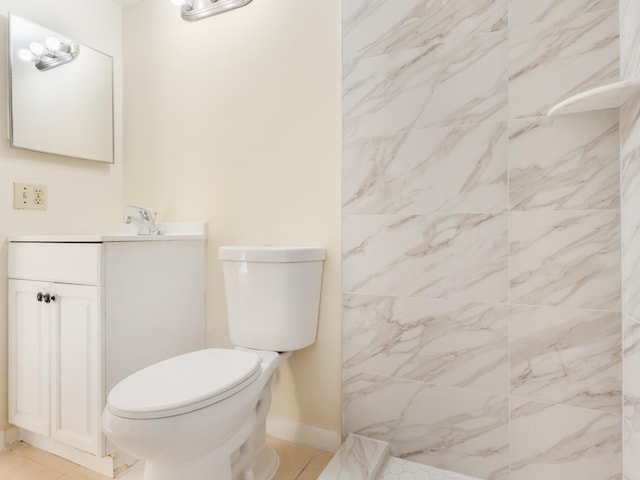 bathroom with vanity, tile patterned floors, toilet, and a tile shower