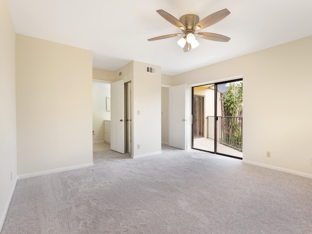 spare room featuring light carpet, visible vents, a ceiling fan, and baseboards