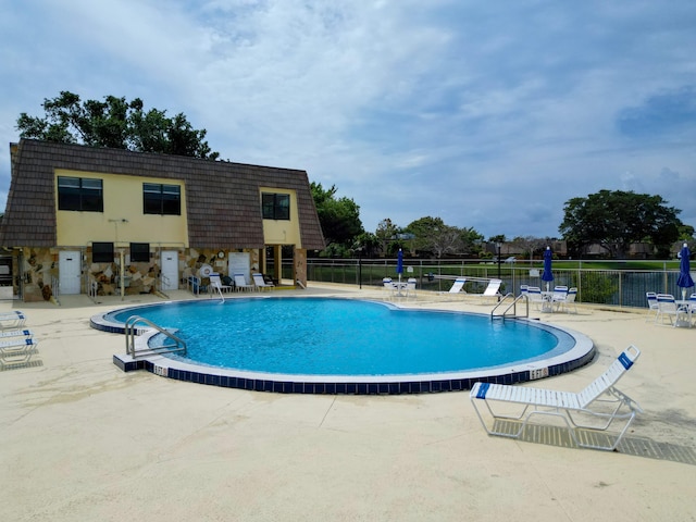 community pool featuring a patio and fence