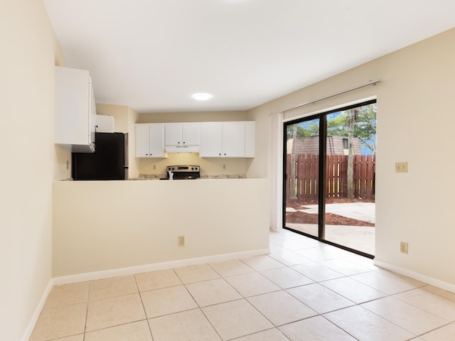 kitchen with a peninsula, electric range, freestanding refrigerator, light countertops, and under cabinet range hood