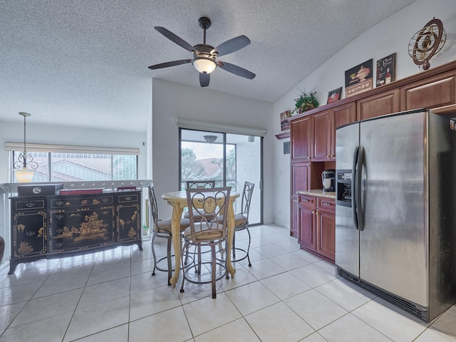 unfurnished dining area featuring light tile patterned floors, baseboards, ceiling fan, vaulted ceiling, and a textured ceiling