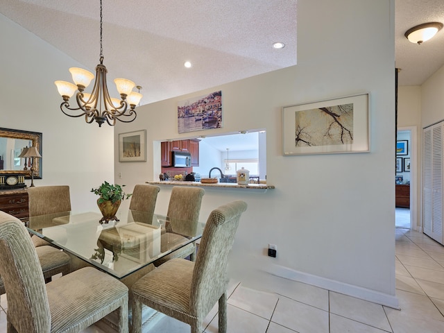 dining area featuring light tile patterned flooring, a textured ceiling, baseboards, and an inviting chandelier