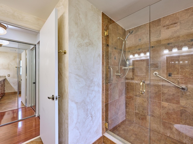 bathroom featuring a shower stall and wood finished floors