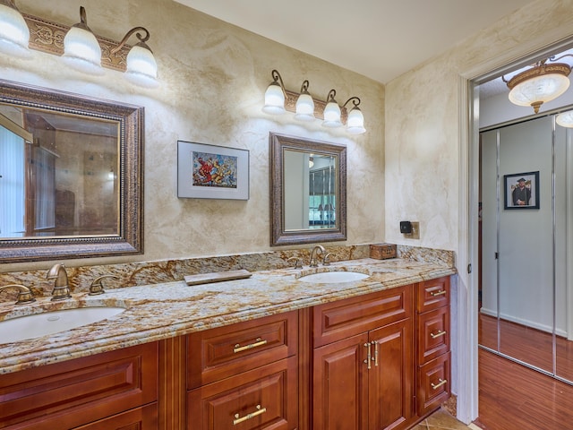 full bathroom featuring double vanity, wood finished floors, and a sink