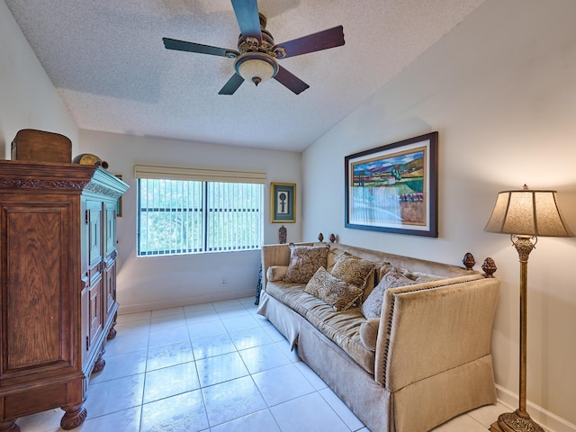 living area with a ceiling fan, lofted ceiling, a textured ceiling, and light tile patterned floors