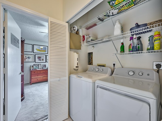 washroom featuring a textured ceiling, laundry area, washer and clothes dryer, and carpet