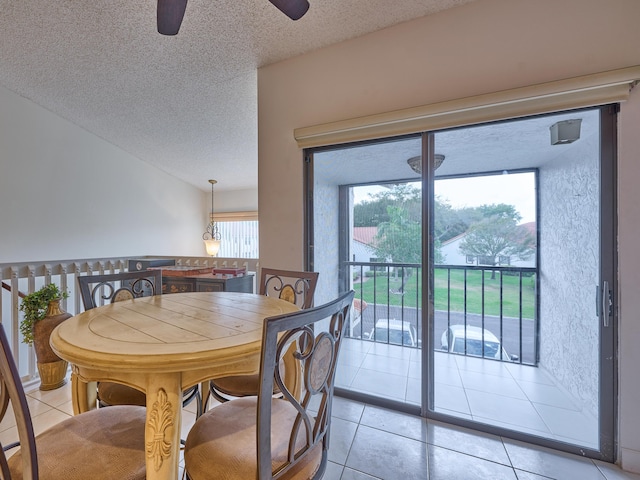 dining space featuring a textured ceiling, light tile patterned flooring, and a ceiling fan