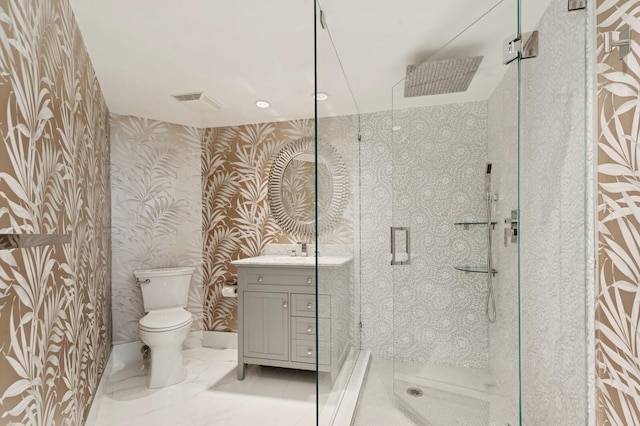 bathroom featuring vanity, a shower stall, toilet, and wallpapered walls