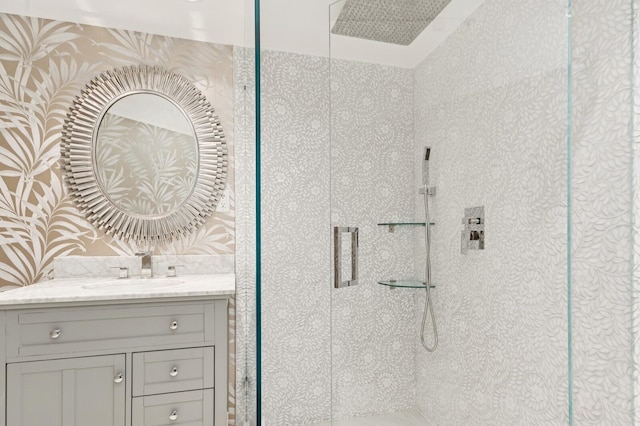 bathroom with a tile shower and vanity