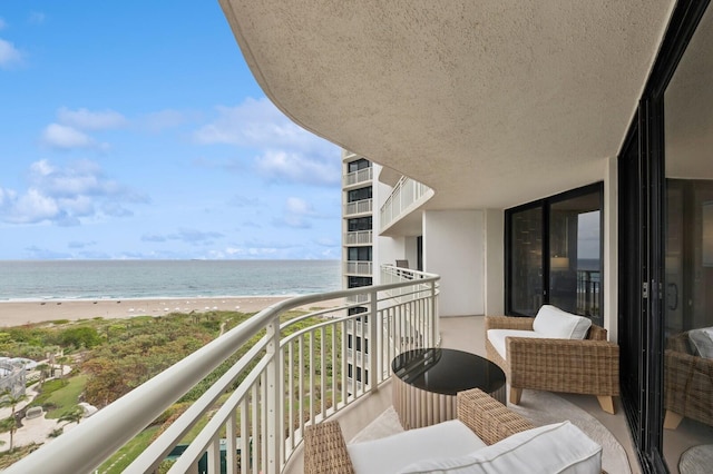 balcony featuring a view of the beach and a water view