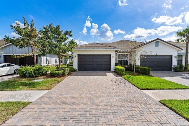 ranch-style home with a garage, decorative driveway, and a tiled roof