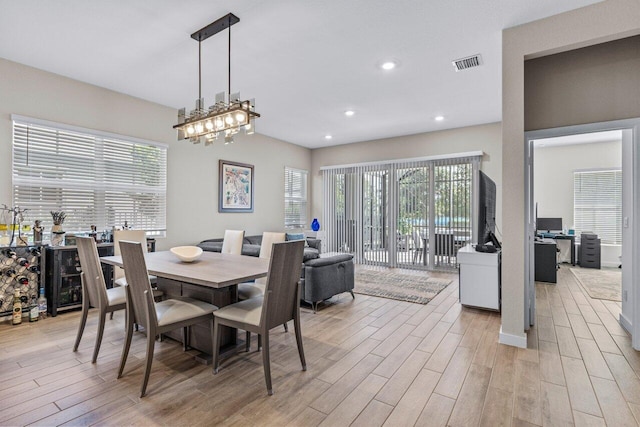 dining room featuring a healthy amount of sunlight, recessed lighting, visible vents, and light wood-style floors