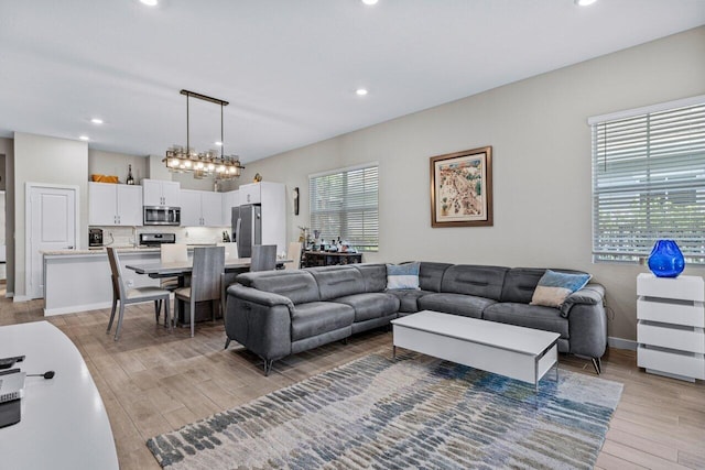 living area with light wood-type flooring, baseboards, and recessed lighting