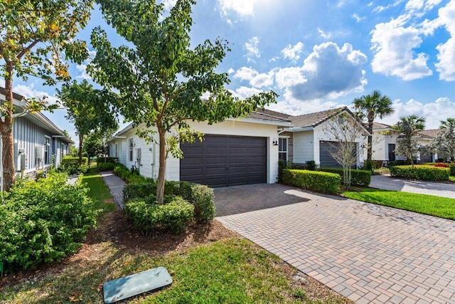 ranch-style house with decorative driveway, an attached garage, and a residential view