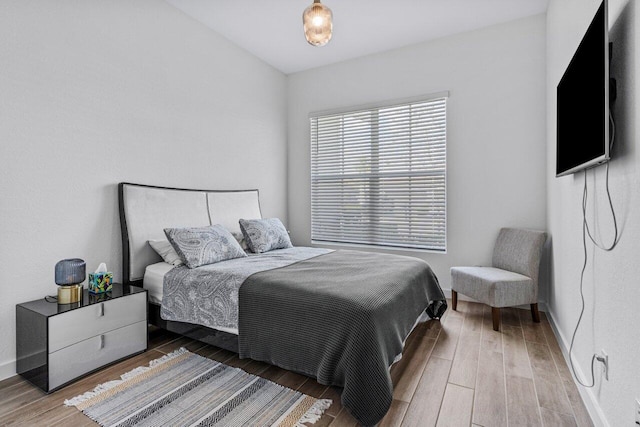 bedroom with baseboards and wood finished floors