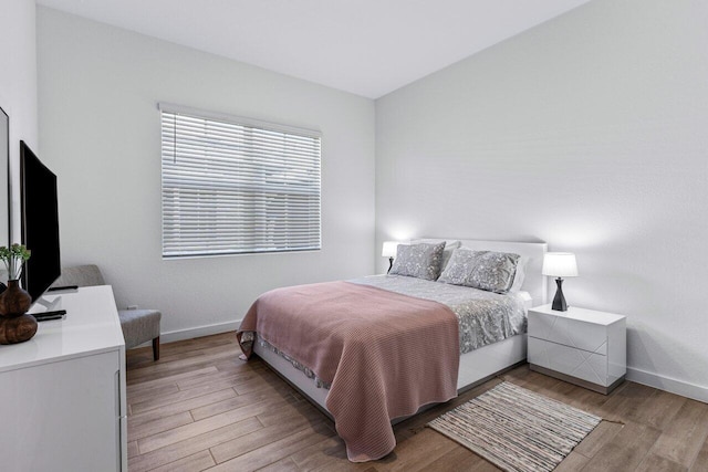 bedroom with light wood-style flooring and baseboards