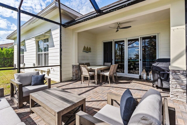 view of patio / terrace with outdoor dining area, glass enclosure, outdoor lounge area, and a ceiling fan