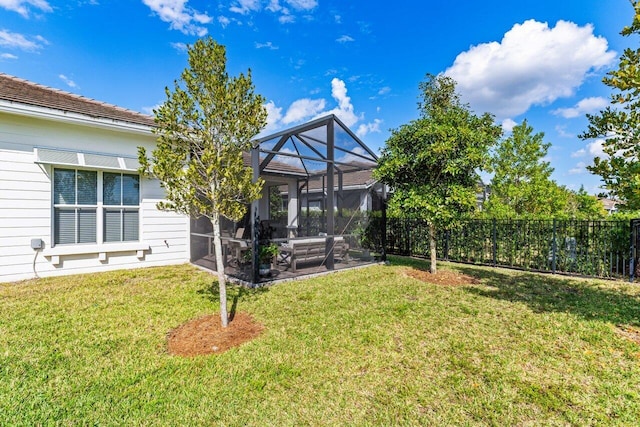 view of yard with a lanai and fence