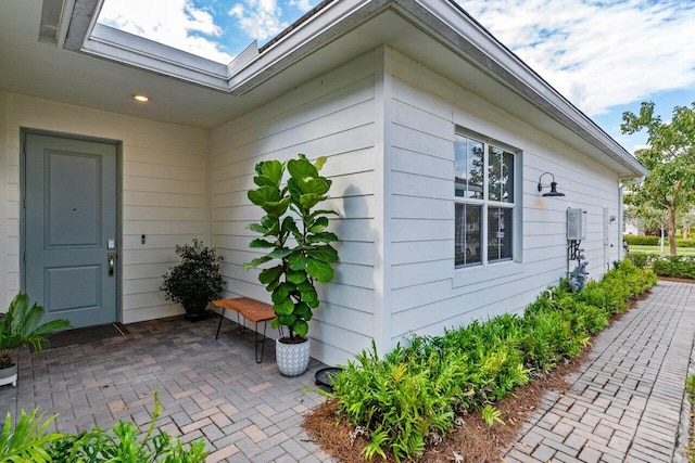 view of exterior entry with a patio area