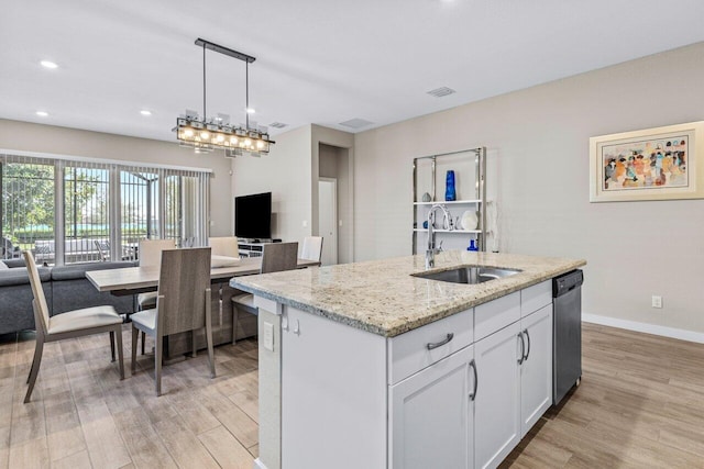 kitchen with open floor plan, a sink, light wood finished floors, and dishwasher