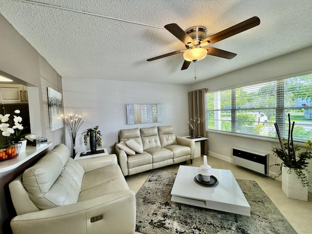 living area with light tile patterned floors, a ceiling fan, and a textured ceiling