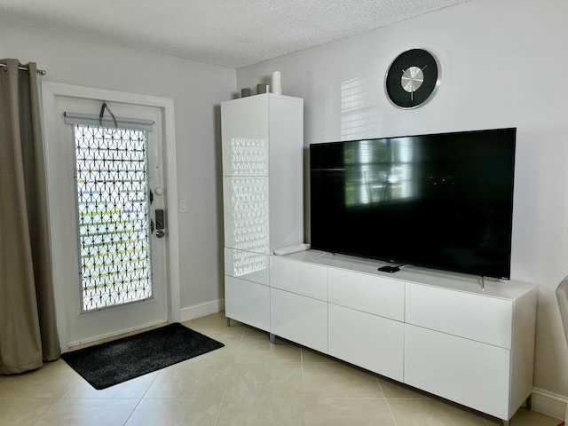 172 Tilford I, Deerfield Beach, FL 33442 - foyer featuring light tile patterned flooring, a healthy amount of sunlight, a textured ceiling, and baseboards