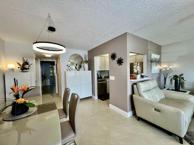 172 Tilford I, Deerfield Beach, FL 33442 - dining space featuring light tile patterned floors, arched walkways, a textured ceiling, and baseboards
