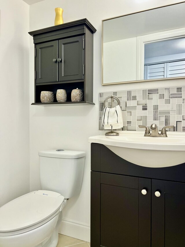 172 Tilford I, Deerfield Beach, FL 33442 - bathroom featuring vanity, toilet, baseboards, and tasteful backsplash