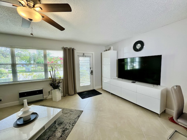 living room with light tile patterned floors, baseboards, a textured ceiling, and ceiling fan