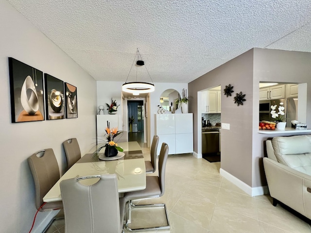 dining room with baseboards, a textured ceiling, and light tile patterned flooring