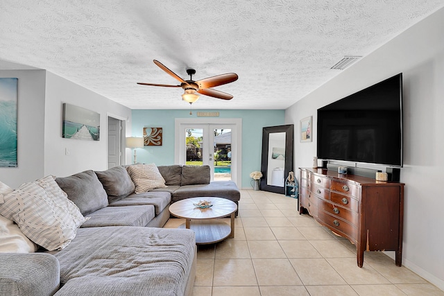 living room with light tile patterned floors, a textured ceiling, visible vents, a ceiling fan, and french doors