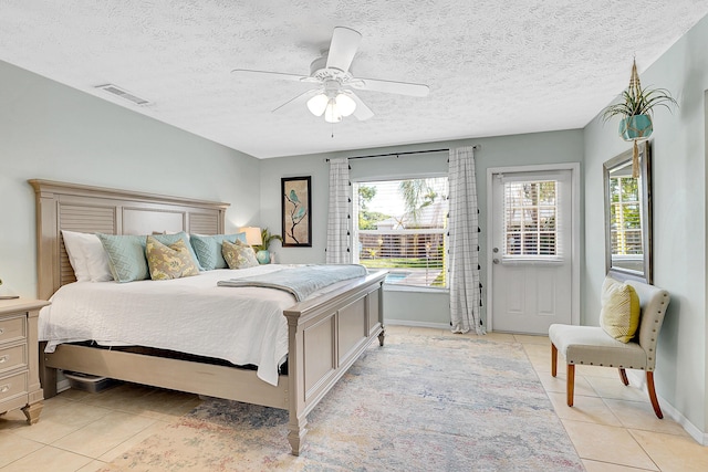 bedroom with a ceiling fan, visible vents, a textured ceiling, and light tile patterned flooring